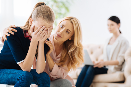 Beautiful adult woman consoling her daughterの写真素材