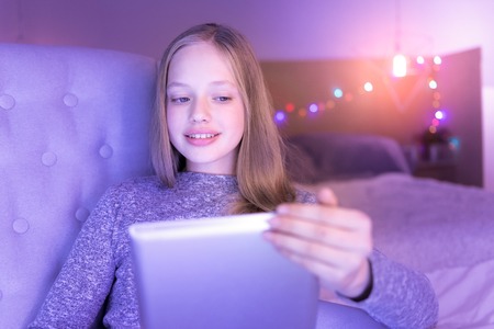 Cheerful girl looking at her tablet