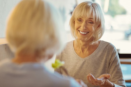 Positive aged woman talking to her friendの写真素材