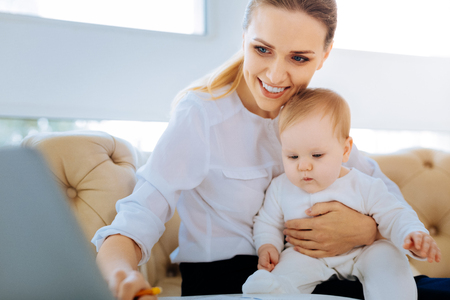 Cute smiling mother holding a pretty babyの写真素材