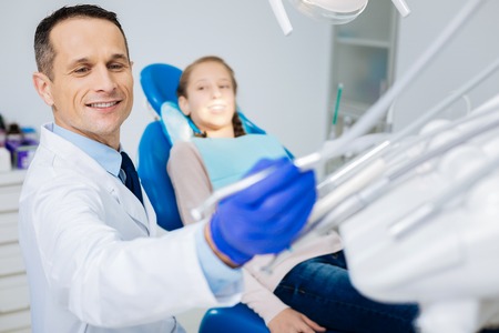 Happy skillful dentist preparing to workの写真素材