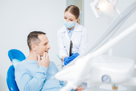 Nice positive man looking at his toothの写真素材