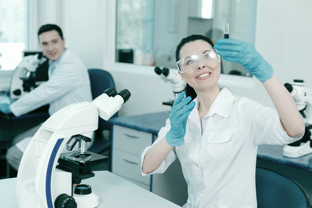 Delighted young woman working in the laboratoryの写真素材