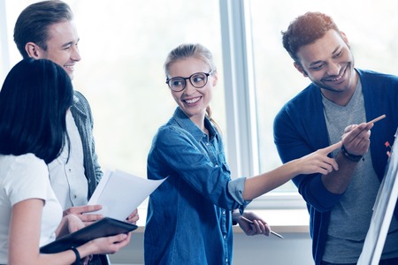 Smiling people looking at board with presentationの写真素材