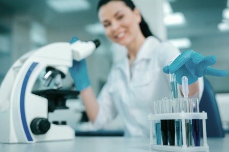 Positive scientist holding glass test tubeの写真素材