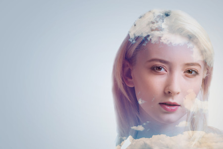 Amazing creativity. Lovely wonderful appealing woman seeing the new means of creation while standing against the grey background  with slightly open mouthの写真素材