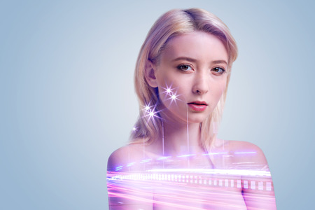 Pensive blonde girl thinking about something while posing and looking into the camera enigmatically.の写真素材