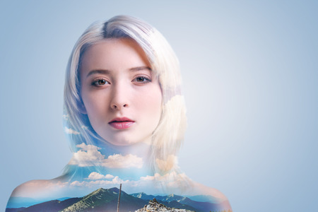 Pretty millennial lady standing against the background and posing for the camera confidently.の写真素材