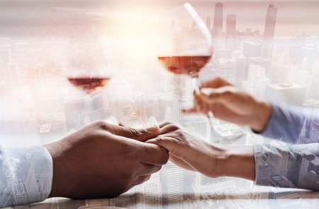 Close up of young adorable couple holding hands while expressing love and respectの写真素材