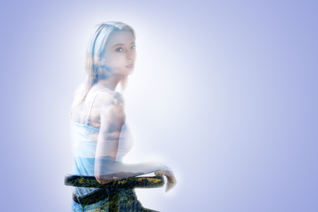 Pleasant nice attractive woman sitting on the bench and enjoying her rest while being in a good moodの写真素材