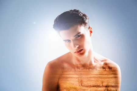 Wild animals. Handsome pleasant young man being in the thoughtful mood and looking at the safari park while bending his headの写真素材