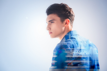 Creative thinking. Nice pleasant handsome man standing and focusing on his thoughts while having creative ideas on his mindの写真素材