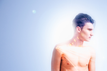 Long road. Handsome pleasant young man standing against blue background and turning his head while imagining a roadの写真素材