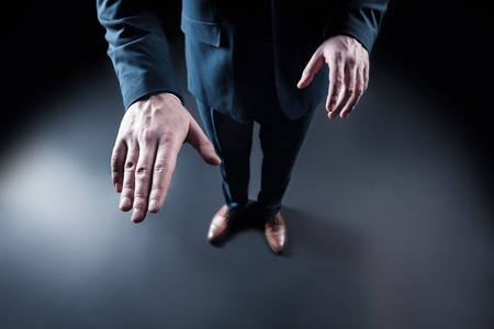 Virtual reality. Top view of a male hand touching the virtual object against the black backgroundの写真素材