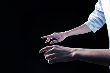 Modern science. Close up of female hands using modern transparent device against the black backgroundの写真素材