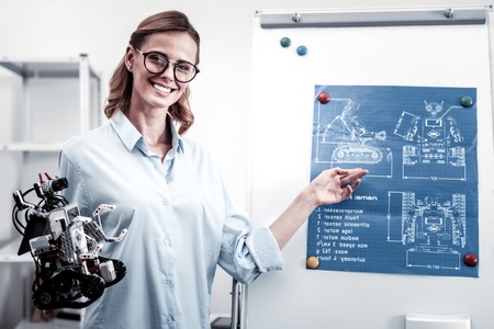 My robot. Amazing young engineer expressing positivity and holding new toy while looking at cameraの写真素材