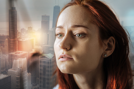 Sad unhappy pretty woman looking aside feeling bad herself and thinking.の写真素材