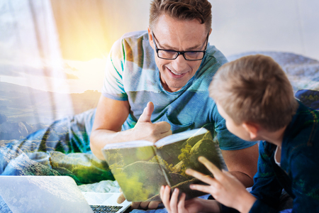 Friendly man wearing glasses and looking at his boy while being very proudの写真素材