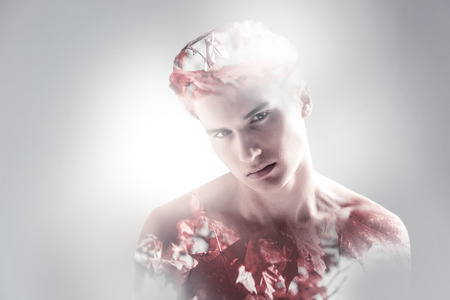 Pensive nice inspired guy looking at the camera while lowering shoulders and asking questionsの写真素材