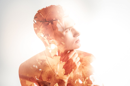 New start. Budding attractive appealing guy starting up while placing hand near the chin and standing in profileの写真素材