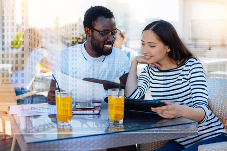 Help me please. Positive delighted bearded man keeping smile on his face and turning head while looking at his friendの写真素材