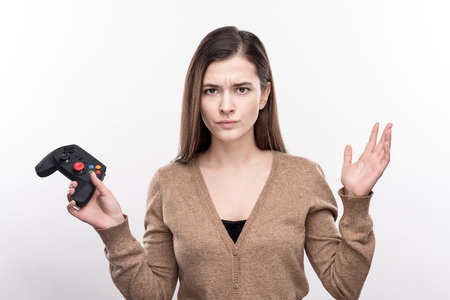 Unfairly defeated. Pretty young woman looking angry, sulking about her loss in the video game while...