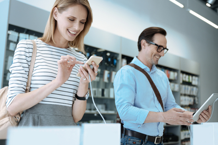 Modern family. Handsome man wearing stylish glasses and keeping smile on face while looking at the tabletの写真素材
