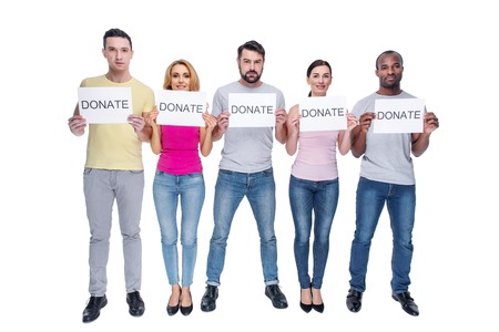 Charity. Attractive inspired kind-hearted young men and women wearing casual clothes and smiling and...