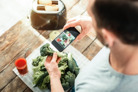 Useful ergonomic cellphone making photo being above vegetables.の写真素材