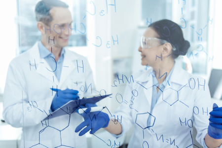 Wonderful breakthrough. Good-looking cheerful smart experienced scientists smiling and writing...