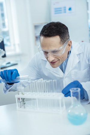 Trace the evolution. Cheerful microbiologist making a research in a labの写真素材