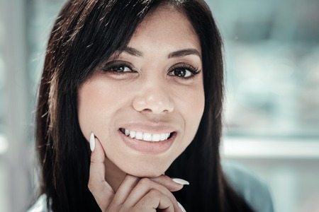 Look at me. Pretty confident satisfied woman being in the bright room smiling and looking straight.