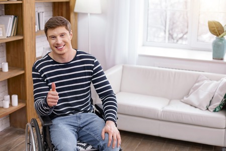 Being satisfied. Handsome young man expressing positivity while spending weekends at homeの写真素材