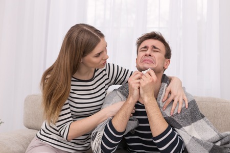 Come down sweetie. Emotional caring woman touching her boyfriend on the shoulder and he cryingの写真素材