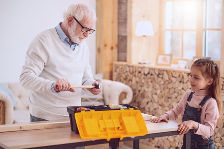 Professional aged locksmith holding his hammer while preparing to workの写真素材