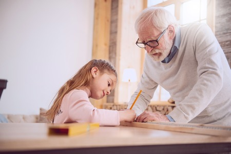 Serious nice girl holding a pencil while making marksの写真素材