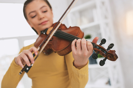 Delighted girl being relaxed while playing favorite melodyの写真素材