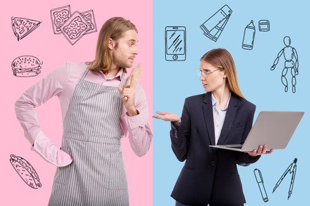 Emotional talk. Emotional serious businesswoman feeling unsatisfied while her calm kind husband standing with a rolling pin and looking at herの写真素材