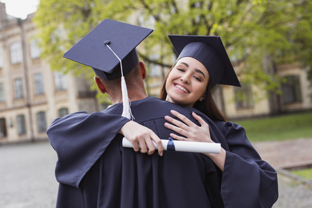 Graduation day. Couple of cute good-looking students feeling extremely happy on their graduation dayの写真素材