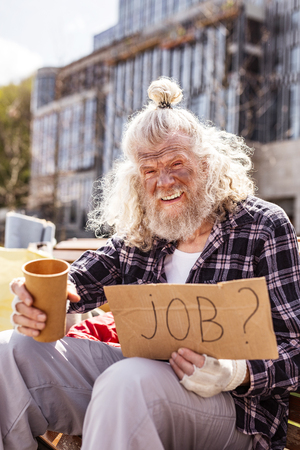 Showing mercy. Depressed jobless man asking for money while being hungryの写真素材