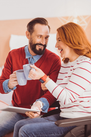 So beautiful. Charming girl holding cup with tea and sitting on the wheelchairの写真素材