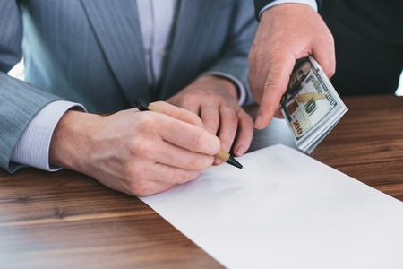New contract terms. Determined unprincipled man writing and a businessman holding money for him