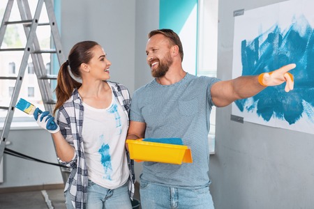 Content skilled painters smiling at each other and talking about their workの写真素材