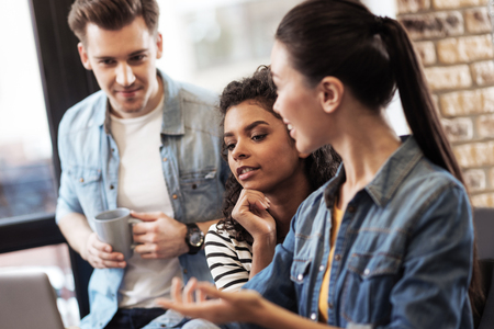 Brainstorm activity. Pleasant smart students discussing their ideas while preparing a projectの写真素材