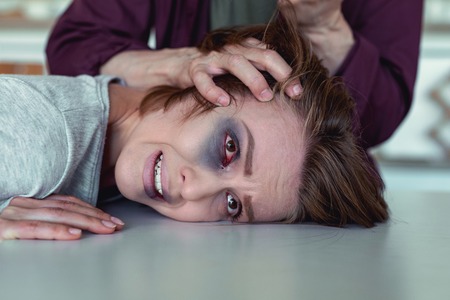 Young wife. Dark-haired young wife crying out loud while having her eye damaged after home violence...