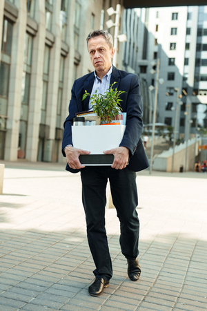 News about dismissal. Dark-eyed fired man feeling extremely melancholic having no words after news about dismissalの写真素材