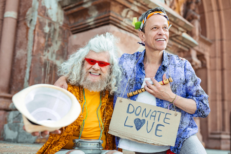 Delighted hippies. Delighted hippies feeling extremely cheerful after their memorable street music performanceの写真素材