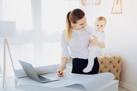 My motivation. Pleased woman bowing head while staring at her childの写真素材