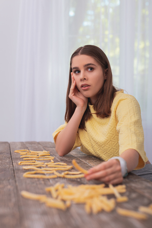 Difficult life. Amazed teen girl touching French fries and opening mouthの写真素材