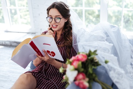Wedding plans. Beautiful charming dark-haired bride telling her lovely handsome man about wedding plansの写真素材